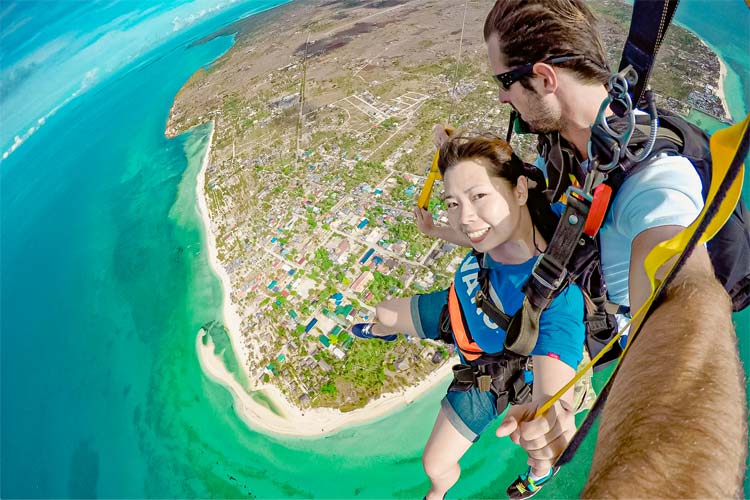 スカイダイビングでパラシュートに乗っている女性