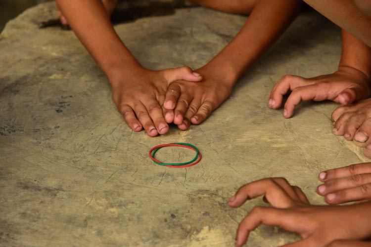アジアの子供達が地面輪ゴムを使用し遊ぶ手