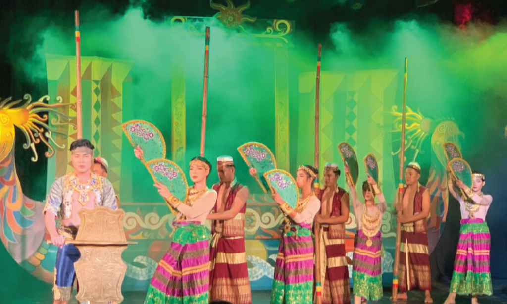 フィリピンの伝統芸能　バンブーダンスのステージ
緑色の照明を背景に、バンブーダンスで使用する丈の棒を運んでいる