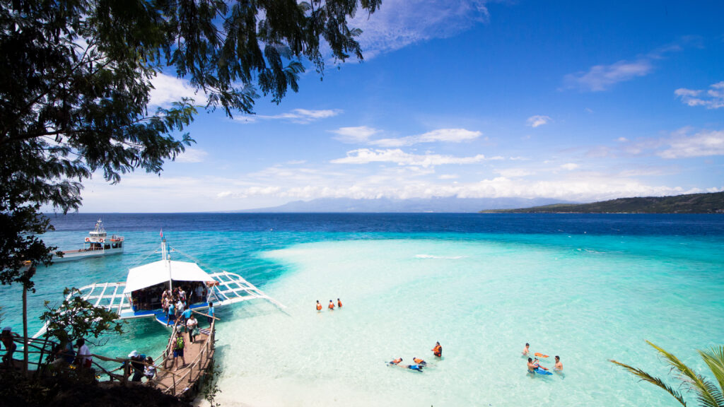 フィリピンの綺麗な海で泳いでいる観光客が写っている写真
